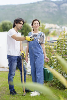 Freund im Gespräch mit seiner Freundin im Garten des neuen Hauses - JSMF02272