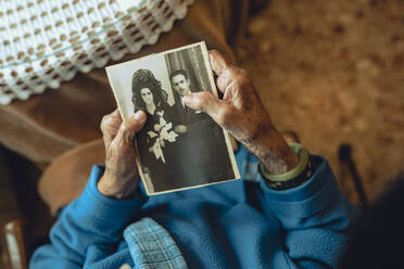 Senior woman with old photograph at home - JCCMF02666