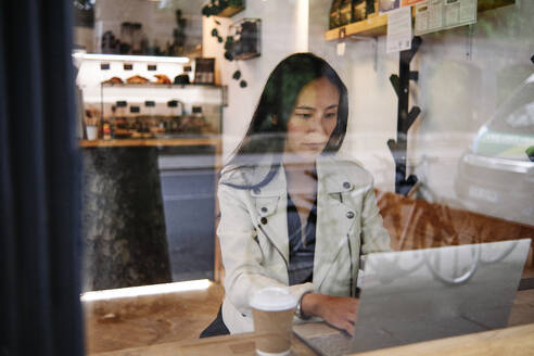 Frau benutzt Laptop in einem Kaffeehaus - ASGF00392