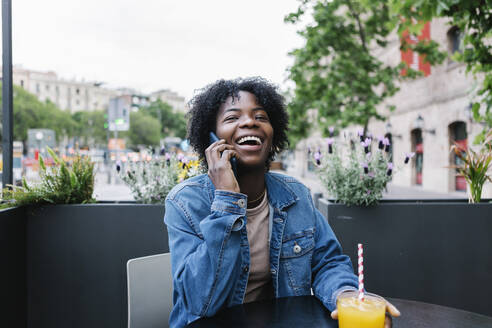 Cheerful woman on mobile phone at cafe - XLGF02015