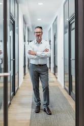 Male entrepreneur standing with arms crossed at office - DIGF15872