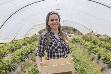 Smiling female farmer working in greenhouse - JRVF00908