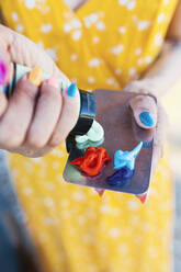 Frau drückt Wasserfarben auf Palette - MRRF01185
