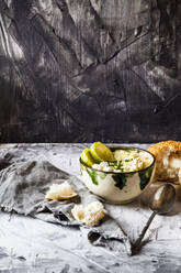 Bowl of Greek avgolemono soup with rice, lemon slices and bread - SBDF04473