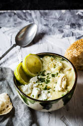 Schüssel mit griechischer Avgolemono-Suppe mit Reis, Zitronenscheiben und Brot - SBDF04474