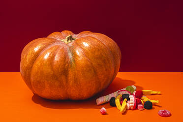 Studioaufnahme von rohem Kürbis und Halloween-Süßigkeiten - FLMF00503