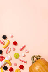 Hintergrund aus verschiedenen Halloween-Süßigkeiten und einem einzelnen Kürbis - FLMF00505