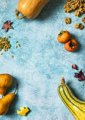 Autumnal background with pumpkins, fallen leaves, pears, walnuts, pumpkin seeds, persimmons and copy space - FLMF00510