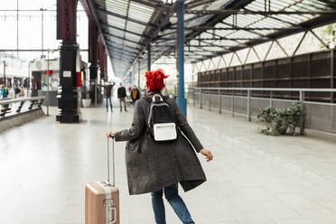 Rothaarige Frau mit Gepäck am Bahnhof - MRRF01229