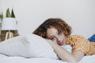 Young woman lying on bed at home - EBBF03838