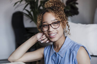 Beautiful smiling woman sitting at home - EBBF03865