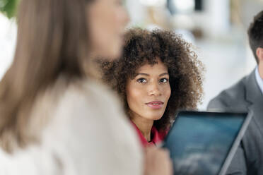 Afro weibliche Fachkraft sieht weibliche Kollegin im Büro an - PESF02898