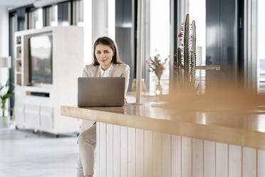 Mittlere erwachsene Geschäftsfrau mit Laptop am Tresen in einer Büro-Cafeteria - PESF02923