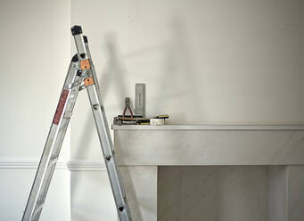 Ladder standing in front of empty fireplace - AJOF01436