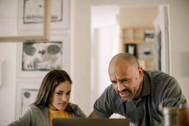 Vater und Tochter benutzen Laptop in der Küche zu Hause - MASF23807