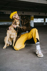 Full length of young man hugging dog in parking garage - MASF23882