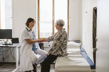 Ärztin prüft den Puls eines älteren Patienten in einer medizinischen Klinik - MASF23908