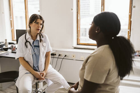 Ärztin im Gespräch mit einem Patienten während einer Konsultation in einer medizinischen Klinik - MASF23955