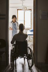 Disabled woman visiting female doctor at medical clinic - MASF23967