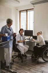 Voller Länge von fröhlichen weiblichen Arzt und behinderte Frau Blick auf ältere Krankenschwester in der medizinischen Klinik - MASF23973