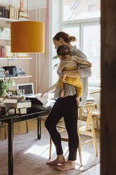 Unternehmerin mit männlichem Kleinkind bei der Arbeit im Heimbüro - MASF24219