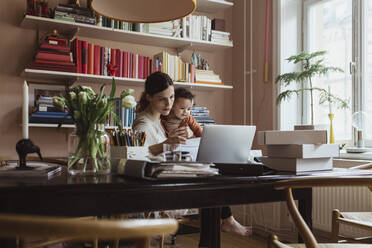 Unternehmerin mit kleinem Sohn arbeitet im Home Office - MASF24236