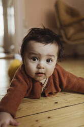 Porträt eines kleinen Jungen, der zu Hause auf dem Boden liegt - MASF24246