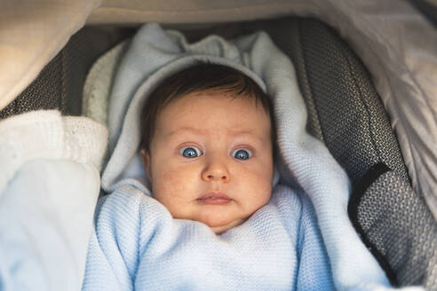 Überraschender kleiner Junge im Kinderwagen liegend - JAQF00664