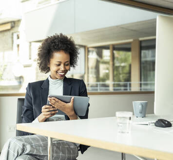 Unternehmerin nutzt digitales Tablet im Büro - UUF23443