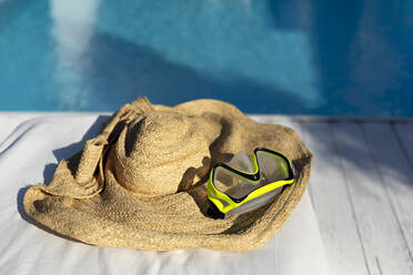 Schwimmbrille auf Jutehut am Swimmingpool - VGF00386