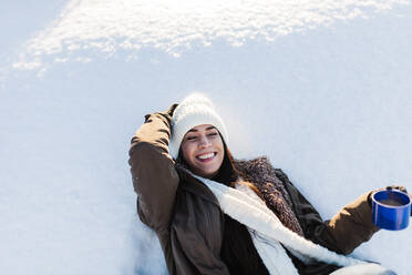 Fröhliche Frau genießt Kaffee im Schnee - MRRF01247