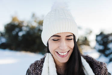 Smiling woman wearing knit hat during winter - MRRF01249