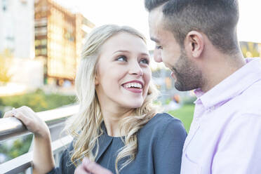 Beautiful woman looking at boyfriend near railing - WPEF04725