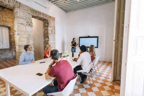 Männliche und weibliche Unternehmer sitzen im Sitzungssaal während einer Besprechung im Coworking-Büro - MPPF01867