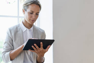 Female entrepreneur using digital tablet in office - SBOF03918