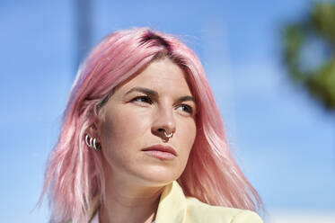 Thoughtful woman with pink hair looking away - KIJF03967