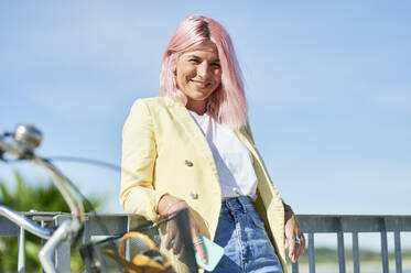 Young woman smiling while leaning on railing - KIJF03969