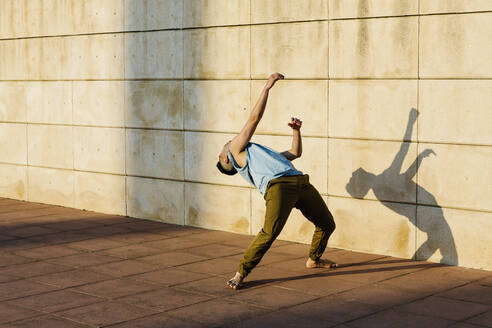 Männlicher Tänzer, der sich beim Tanzen auf dem Gehweg nach hinten beugt - XLGF02062