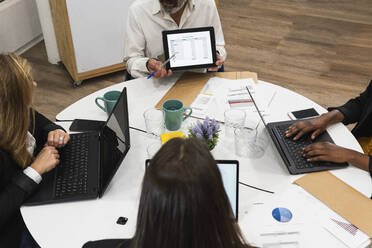 Businessman discussing business plan with female coworkers at office - PNAF01864