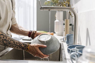 Mann wäscht Schüssel in Waschbecken zu Hause - EYAF01652