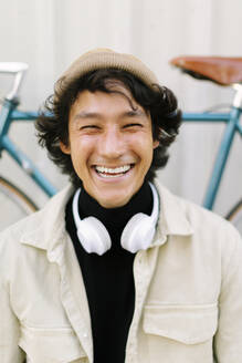 Cheerful man squinting eyes in front of bicycle - AGGF00123