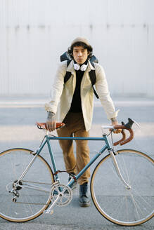 Handsome man leaning on bicycle - AGGF00125