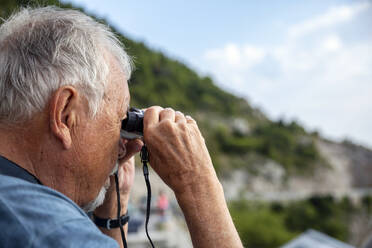 Senior man looking through binoculars - MAMF01855