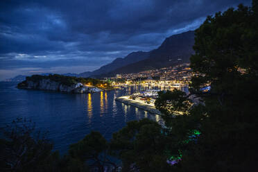 Kroatien, Gespanschaft Split-Dalmatien, Makarska, Beleuchteter Hafen von Makarska Riviera bei Nacht - MAMF01874
