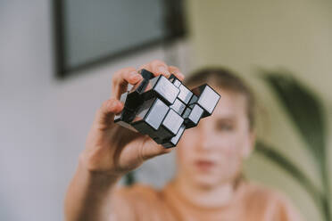 Girl holding toy block at home - MFF08119