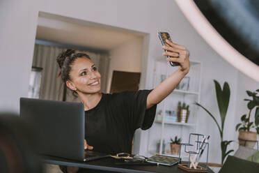 Geschäftsfrau nimmt Selfie durch smart phone im Büro - MFF08161