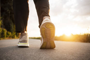 Woman walking on road during sunset - CHPF00772