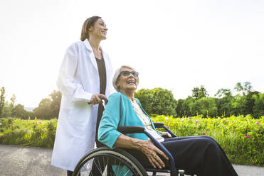 Lächelnde Seniorin mit Hausmeister im öffentlichen Park - OIPF00896