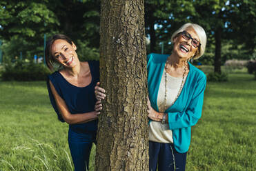 Happy senior woman with mid-adult woman in public park - OIPF00898