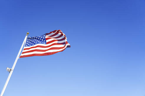 Amerikanische Flagge weht an einem sonnigen Tag - AZF00343